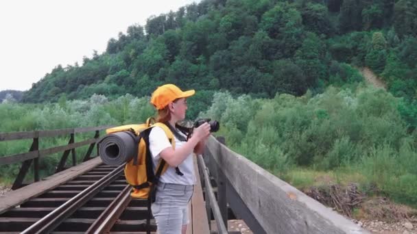 Bir Kadın Turist Köprüdeki Tren Yolu Boyunca Sırt Çantasıyla Yürüyor — Stok video