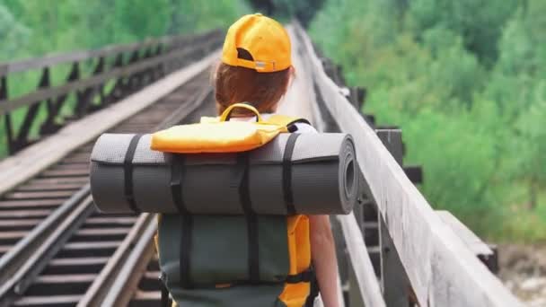 Eine Touristin Läuft Mit Einem Rucksack Über Die Bahngleise Auf — Stockvideo