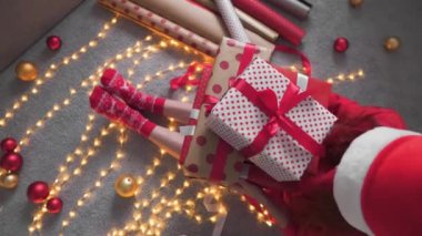 Kız kırmızı kağıtlı, renkli kurdeleli yeni yıl paketleri yapıyor. Genç bir kadın arkadaşları ve akrabaları için Noel hediyesi paketliyor. Noel süslemeleri, tatil sezonu hazırlıkları..