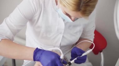 Kozmetik uzmanı kırışıklıkları mikro akımla düzeltiyor. Kozmetolojide donanım prosedürü. Bir güzellik kliniğinde soyma, fonofort, masaj ve yüz gerdirme..