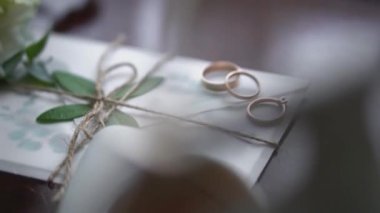 Düğün gereçleri. Düğün buketi olan beyaz düğün ayakkabıları. Gelin ve damat için altın alyanslar. Estetik tasarım ve düğün günü stili.