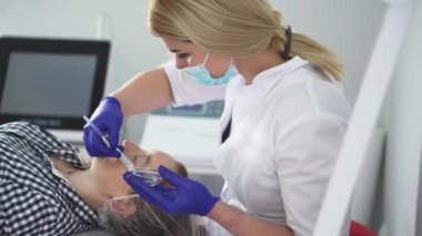Kozmetik uzmanı kırışıklıkları mikro akımla düzeltiyor. Kozmetolojide donanım prosedürü. Bir güzellik kliniğinde soyma, fonofort, masaj ve yüz gerdirme..