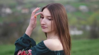 Çimenlerin ve çiçeklerin arasında doğada yaşayan güzel esmer kız. O, tarlanın ortasında yürüyor ve dinleniyor. Doğal kozmetik ürünleri ve cilt bakımı.