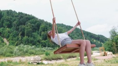 Bir kadın yaz parkında rahatlar ve eğlenir. Kızıl saçlı bir kız doğada salıncakta sallanıyor. Hayal kurmayı, rahatlamayı ormanda salıncakta sallanmayı ve çocukluğunu hatırlamayı sever..