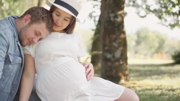 美丽的孕妇和她的丈夫抱着她的肚子 未来的母亲和父亲都期待着孩子的出生 他们的第一个孩子 年轻家庭的怀孕和幸福 — 图库视频影像