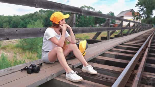 Kobieta Podróżnik Turystyczny Siedzi Czeka Plecakiem Torach Kolejowych Moście Dziewczyna — Wideo stockowe