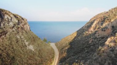 Deniz kenarındaki dağ manzarası. Karadeniz yakınlarındaki bir kanyonda sarımsı kırmızı kayalar. Dağlar.