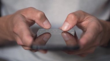 Akıllı telefondaki hayat. Genç bir adam cep telefonuna bakar ve sosyal ağlara yakından bakar. Rahat yetişkin bir adam akşamları cep telefonu uygulaması okuyor. Cep telefonu parmaklarına dokun..