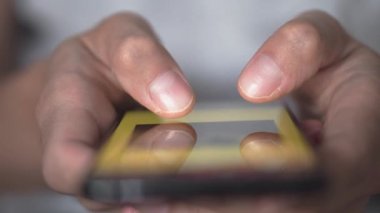 Akıllı telefondaki hayat. Genç bir adam cep telefonuna bakar ve sosyal ağlara yakından bakar. Rahat yetişkin bir adam akşamları cep telefonu uygulaması okuyor. Cep telefonu parmaklarına dokun..