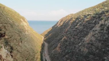 Deniz kenarındaki dağ manzarası. Karadeniz yakınlarındaki bir kanyonda sarımsı kırmızı kayalar. Dağlar.