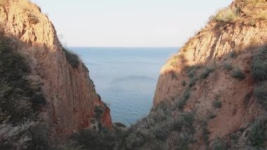 Deniz kenarındaki dağ manzarası. Karadeniz yakınlarındaki bir kanyonda sarımsı kırmızı kayalar. Dağlar.