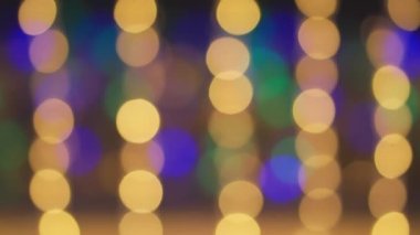 Bir Noel ağacından gelen ışık bokeh. Bulanık Noel ışıkları. Parıldayan soyut renkli daireler noel ışıklarının dikkatini dağıttı. Odak dışı tatil dekoru, tema ve konsept geçmişi.