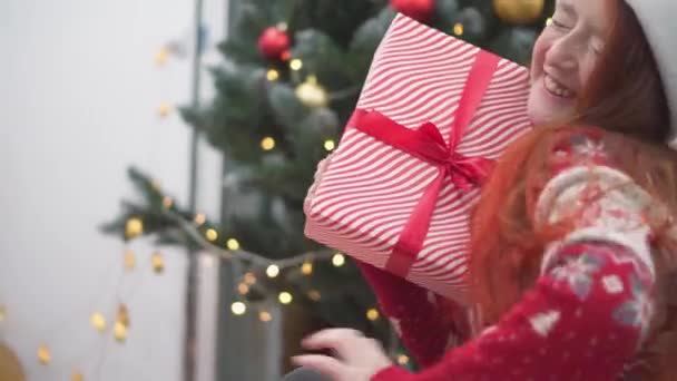 Flicka Nära Jul Presentförpackning Bakgrund Julbelysning Girlanger Och Öppen Spis — Stockvideo