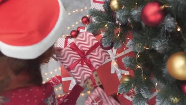 Девушка Возле Рождественских Подарочных Коробок Заднем Плане Рождественские Огни Гирлянды — стоковое видео