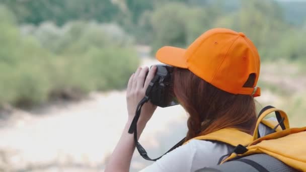 Młoda Kobieta Robi Zdjęcia Lustrzanką Wędrówki Kamerą Pomarańczowym Plecakiem Czapką — Wideo stockowe