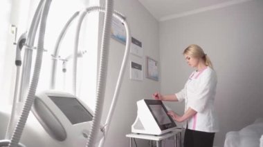 Kozmetolojide donanım prosedürü. Güzellik kliniğinde soyulan, fonoresis, masaj ve yüz gerdirme. Kozmetik uzmanı kırışıklıkları mikro akımla düzeltiyor.