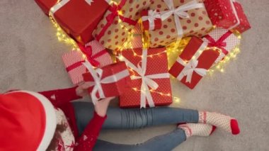 Noel ağacının yanında genç bir kadın ve hediye kutuları. Yeni yıl arifesinde mutlu bir kız. Yılbaşı tatili için hazırlıkların atmosferi, bir kış masalı ve evde Noel havası. Sihirli anlar.