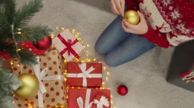 Noel ağacının yanında genç bir kadın ve hediye kutuları. Yeni yıl arifesinde mutlu bir kız. Yılbaşı tatili için hazırlıkların atmosferi, bir kış masalı ve evde Noel havası. Sihirli anlar.