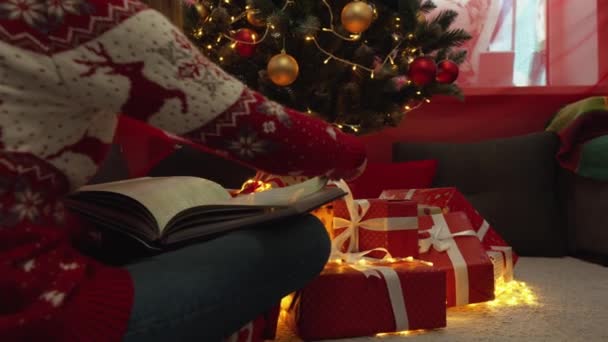 圣诞树旁和礼品盒旁的一位年轻女子 除夕快乐的女孩 新年假期的准备气氛 一个冬天的童话和圣诞节的气氛在家里 神奇的时刻 — 图库视频影像