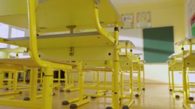 Okul beyaz ve yeşil karatahtalı boş sınıflar, eğitim amaçlı sarı masalar ve ilkokul dersleri için sandalyeler. Çocuklar için eğitim, çocuklar için eğitim kavramı