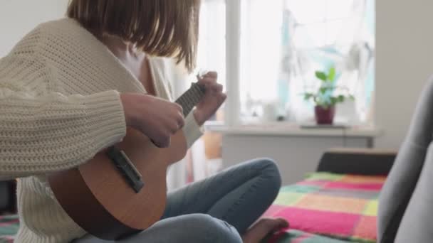 Ukulele Kobiecych Rękach Kobieta Uczy Się Grać Ukulele Domu Siedząc — Wideo stockowe