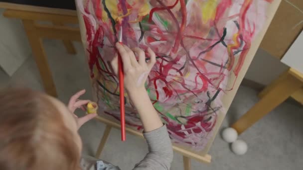 她是一位才华横溢 富有创新精神的女画家 画上画笔 用多种颜色的绘画 创作出一副五彩缤纷 感情用事的画面 现代艺术家创作抽象的现代艺术 女孩画画 — 图库视频影像