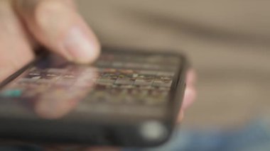 A mans finger touches a monitor to scroll a page on a mobile phone. Viewing photos and documents in the smartphone library. A man in his hands uses a smartphone, turns pages.