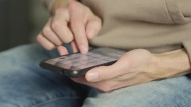 A mans finger touches a monitor to scroll a page on a mobile phone. Viewing photos and documents in the smartphone library. A man in his hands uses a smartphone, turns pages.