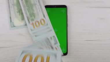 Smartphone green blue screen, man counting dollars cash. Paper money and mobile phone chroma key. Hands hold American dollars, put on table. Banking, work and earnings Internet online and business