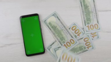 Smartphone green blue screen, man counting dollars cash. Paper money and mobile phone chroma key. Hands hold American dollars, put on table. Banking, work and earnings Internet online and business