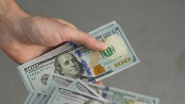Close-up of male hands counting a stack of US hundred dollar bills. Businessman counts cash. concept of investment, money exchange, credit and deposit. Salary to employees for work.