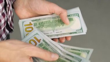 Close-up of male hands counting a stack of US hundred dollar bills. Businessman counts cash. concept of investment, money exchange, credit and deposit. Salary to employees for work.