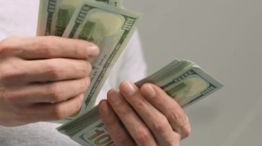 Close-up of male hands counting a stack of US hundred dollar bills. Businessman counts cash. concept of investment, money exchange, credit and deposit. Salary to employees for work.