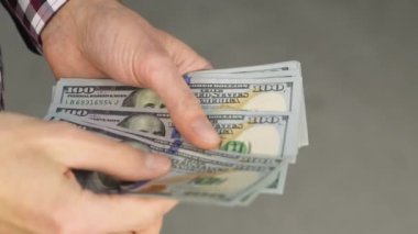 Close-up of male hands counting a stack of US hundred dollar bills. Businessman counts cash. concept of investment, money exchange, credit and deposit. Salary to employees for work.