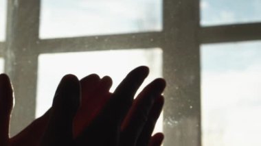 Human hand on background of sun. Backlight silhouette sunlight at sunset sunrise. The concept of love, dream, religion, faith in god, prayer, meditation. Christian Muslim raises his hands to the sky.