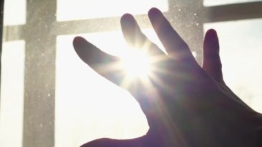 Human hand on background of sun. Backlight silhouette sunlight at sunset sunrise. The concept of love, dream, religion, faith in god, prayer, meditation. Christian Muslim raises his hands to the sky.