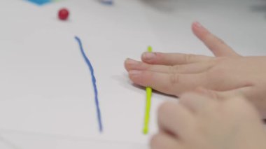 Children sculpt with their hands on a table made of polymer clay. Multi-colored plasticine is a developing activity for boys and girls. Master class and childrens game training and sculpting hobby