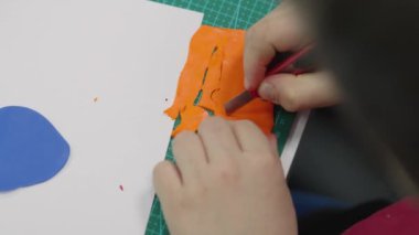 Children sculpt with their hands on a table made of polymer clay. Multi-colored plasticine is a developing activity for boys and girls. Master class and childrens game training and sculpting hobby