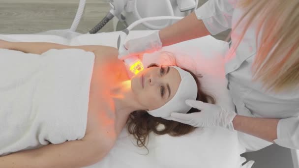赤いLed治療 顔の皮膚療法をしている女性 放射線の顔を持ち上げる ハードウェアのアンチエイジング手順 Rfリフティングと真空マッサージ 美容師が美容整形を行います — ストック動画