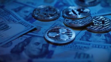 Kripto para birimi Bitcoin, Ethereum, Bağlantı, Binance USD, XRP, Dogecoin ve mavi arka planda Amerikan doları banknotları. Kripto değiş tokuşu. Dijital mali işlemleri engelle. Yatırım işi