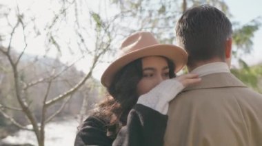 Young couple on walk in park in the spring. A romantic meeting of a happy boy and girl on vacation in the forest. Love and relationship between a man and a woman. Smiles, hugs and emotions at sunset.