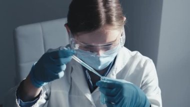 Tıbbi araştırma laboratuarı. Bir bilim adamı pipet ve test tüpüyle çalışır. Biyoteknoloji, kimya, biyokimya ve deneyler alanındaki tıp ve araştırmaların geliştirilmesi.