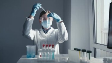 Tıbbi araştırma laboratuarı. Bir bilim adamı pipet ve test tüpüyle çalışır. Biyoteknoloji, kimya, biyokimya ve deneyler alanındaki tıp ve araştırmaların geliştirilmesi.