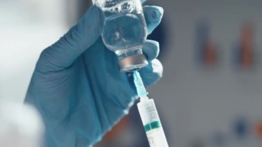 Doktor şırıngayı ilaçla doldurur. Hastane laboratuvarında bir hemşire iğneye hazırlanıyor. Konsept: tedavi, yardım, aşı, aşı, aşı, sağlık, ilaç, tıbbi laboratuvar.