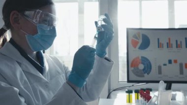 Doktor şırıngayı ilaçla doldurur. Hastane laboratuvarında bir hemşire iğneye hazırlanıyor. Konsept: tedavi, yardım, aşı, aşı, aşı, sağlık, ilaç, tıbbi laboratuvar.