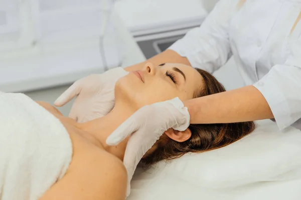 Kvinna Kosmetolog Applicerar Kräm Ansiktet Med Massage Vård Avslappning Föryngring — Stockfoto