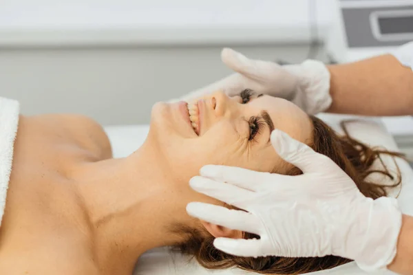 Kvinna Kosmetolog Applicerar Kräm Ansiktet Med Massage Vård Avslappning Föryngring — Stockfoto