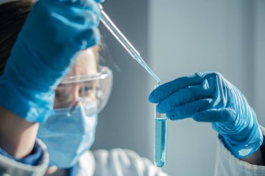 Tıbbi araştırma laboratuarı. Bir bilim adamı pipet ve test tüpüyle çalışır. Biyoteknoloji, kimya, biyokimya ve deneyler alanındaki tıp ve araştırmaların geliştirilmesi.