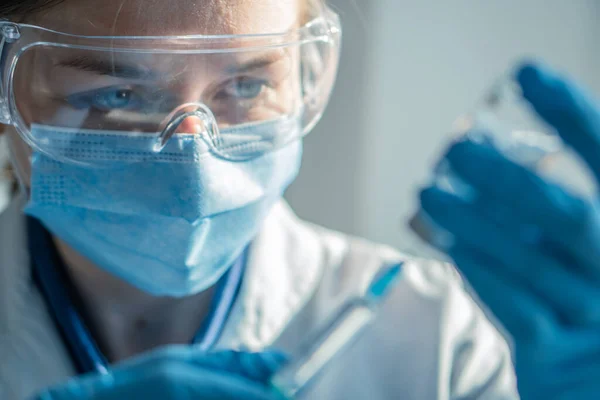 stock image The doctor fills the syringe with medicine. A nurse in a hospital laboratory prepares for an injection. Concept: treatment, help, vaccine, vaccination, healthcare, pharmaceutics, medical laboratory.