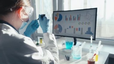 İlaç geliştiren biyoteknoloji uzmanıyla tıp bilimi laboratuvarı, farmasötik bölümünde çalışan kadın biyokimyacı. Tıbbi analiz ve deneylerin araştırması. Arka ve yan görünüm Görüntüsü